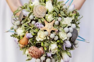 Bouquet de novia con conchas y estrellas de mar para matrimonio en la playa