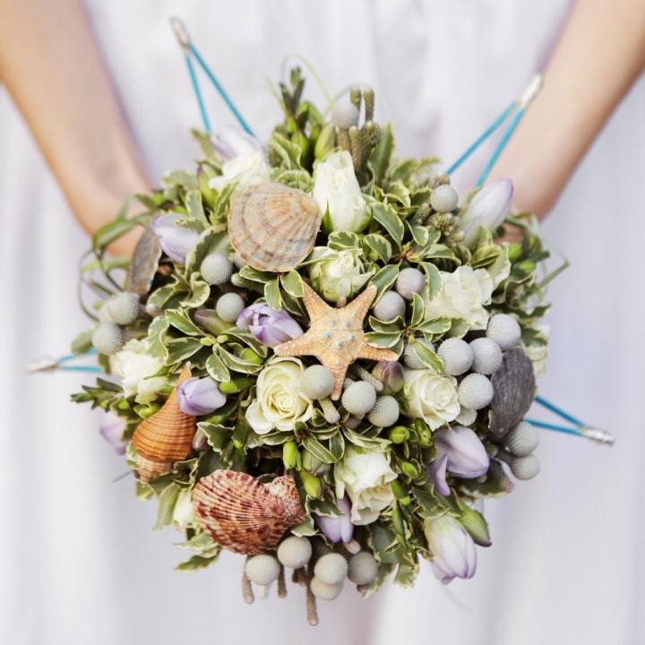 Bouquet de novia con conchas y estrellas de mar para matrimonio en la playa