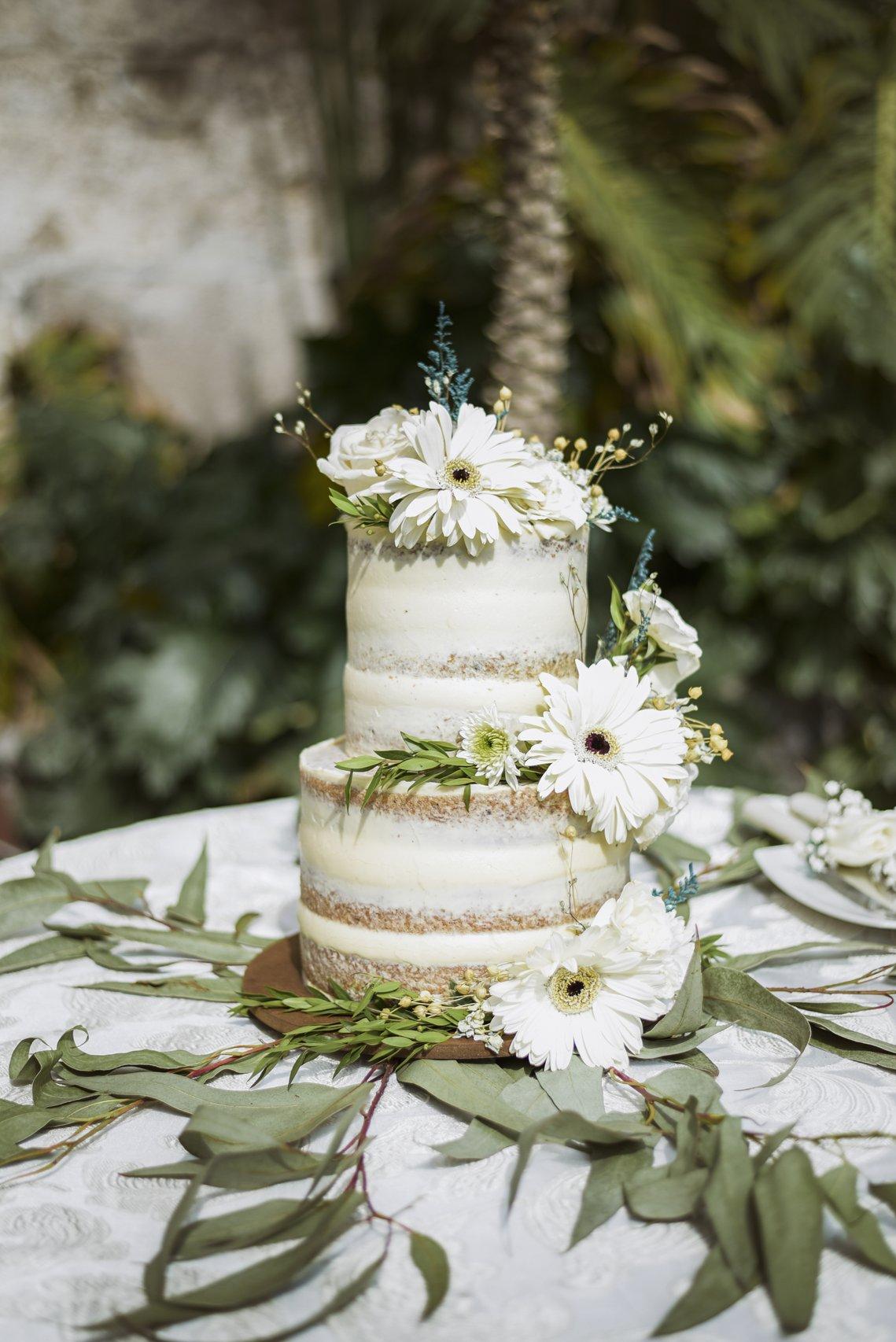 torta de matrimonio elegante e tres pisos con flores naturales