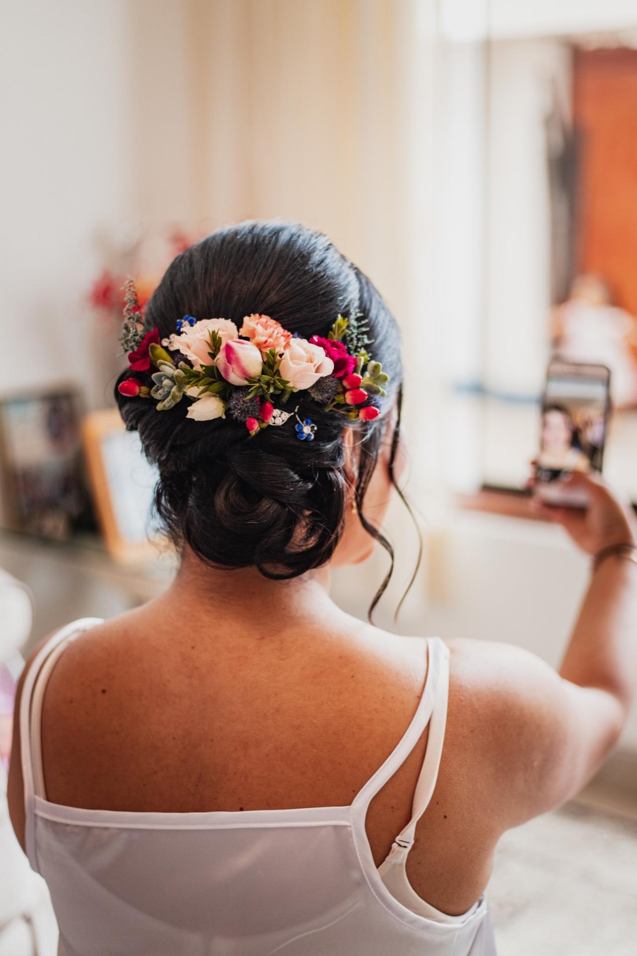 peinado de novia recogido con flores blancas y rosadas