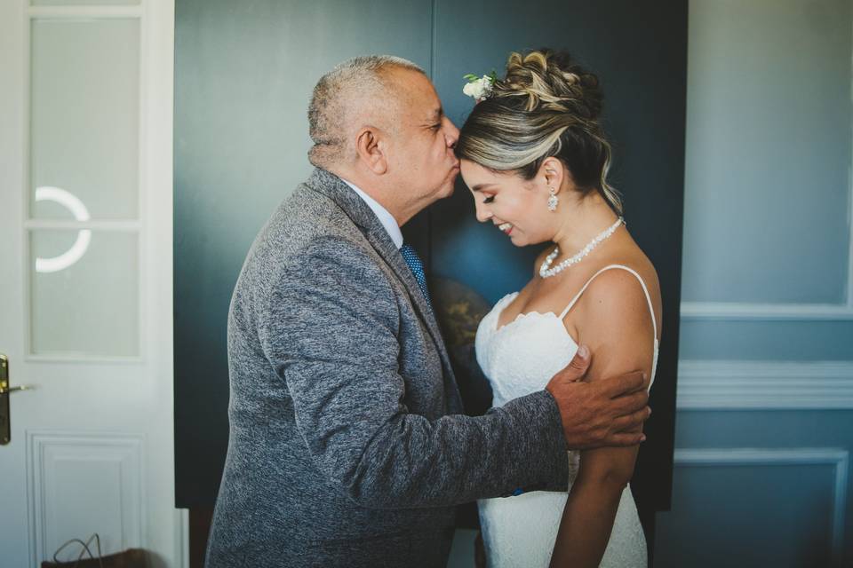 Padre besa en la frente a su hija con amor