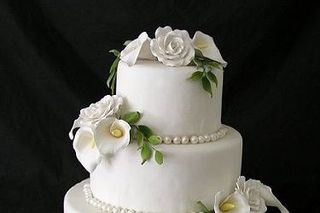 torta de matrimonio elegante e tres pisos de color blanco con flores de azúcar