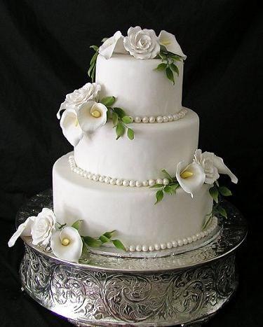 torta de matrimonio elegante e tres pisos de color blanco con flores de azúcar