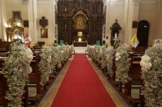alfombra roja con arreglos florales como decoración de iglesia para boda