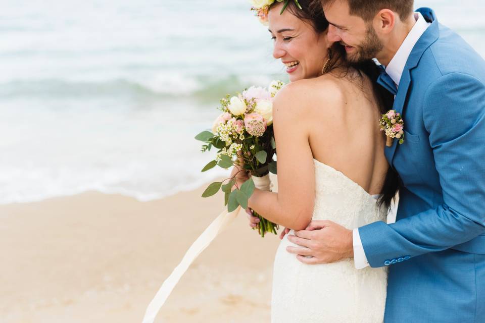 pareja de novios felices abrazados la novia con su bouquet de novia