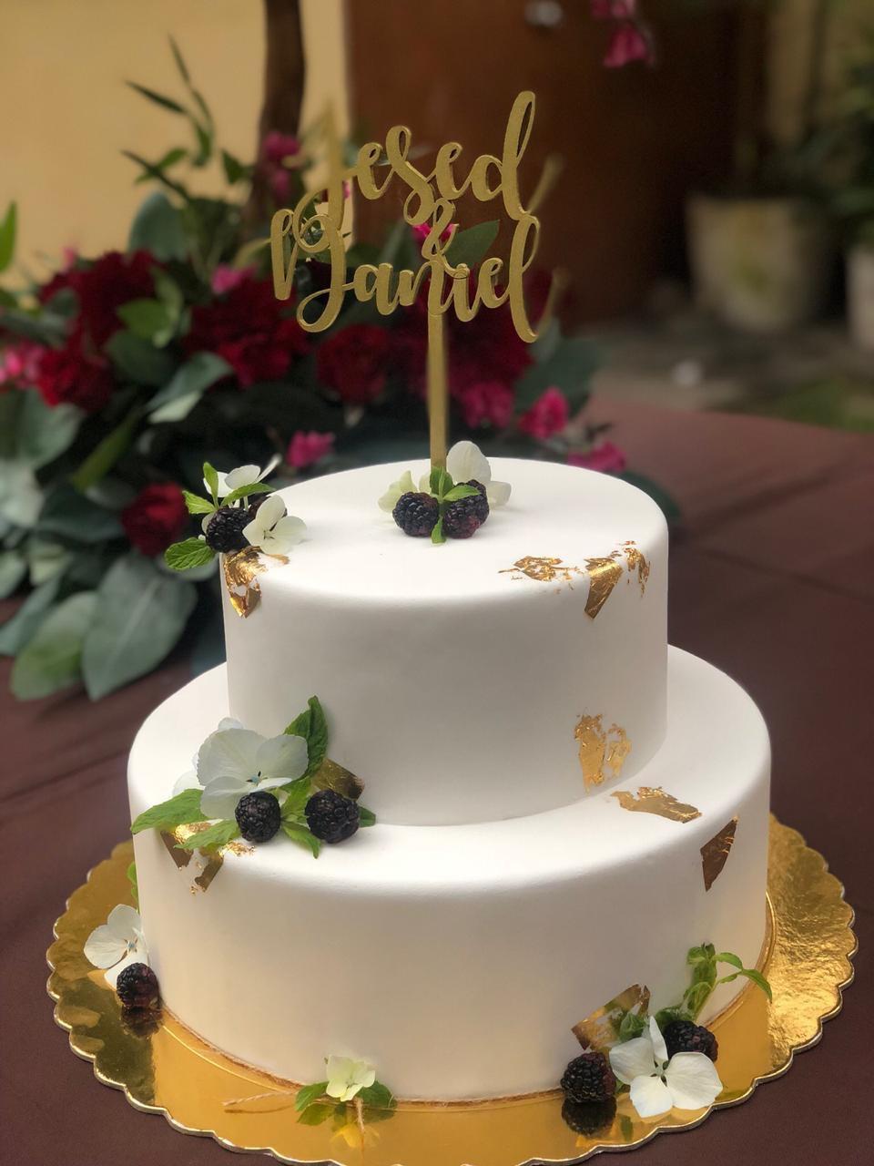 torta de matrimonio elegante de dos pisos con decoración con hojas verdes minimalista