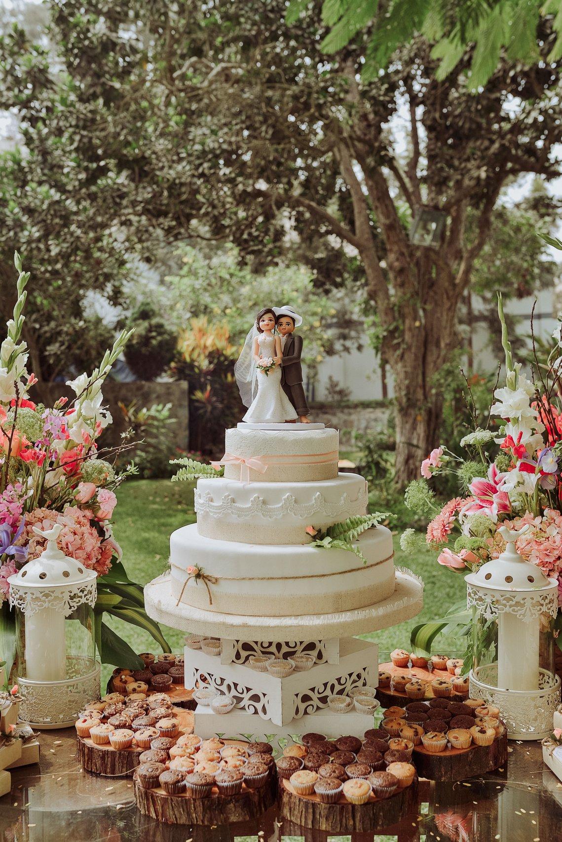 mesa de dulces con torta de matrimonio de varios pisos al aire libre