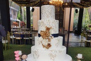 torta de matrimonio elegante de cuatro pisos blanca con toques dorados