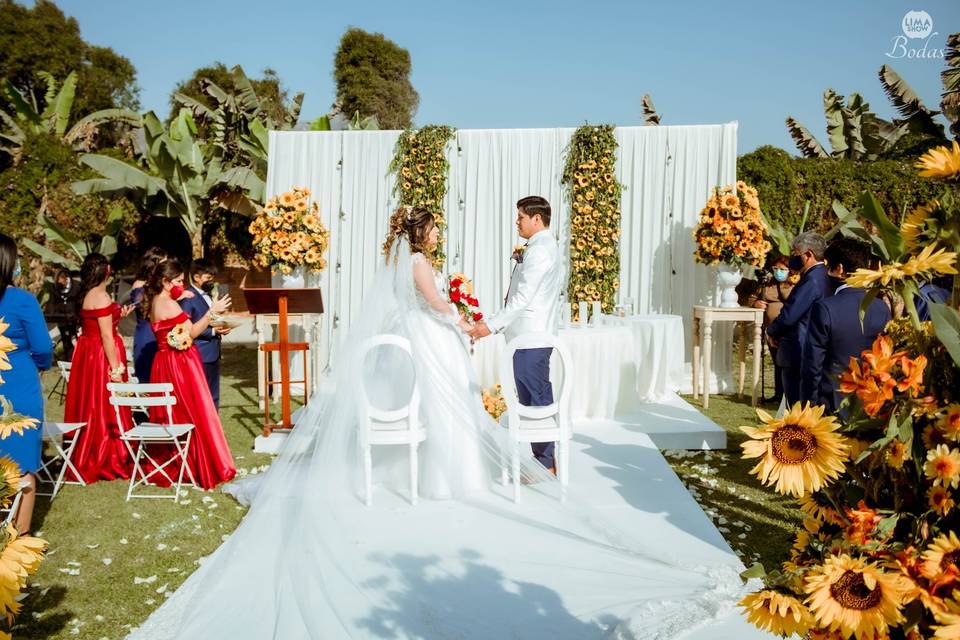altar de matrimonio decorado con telas y flores de girasol