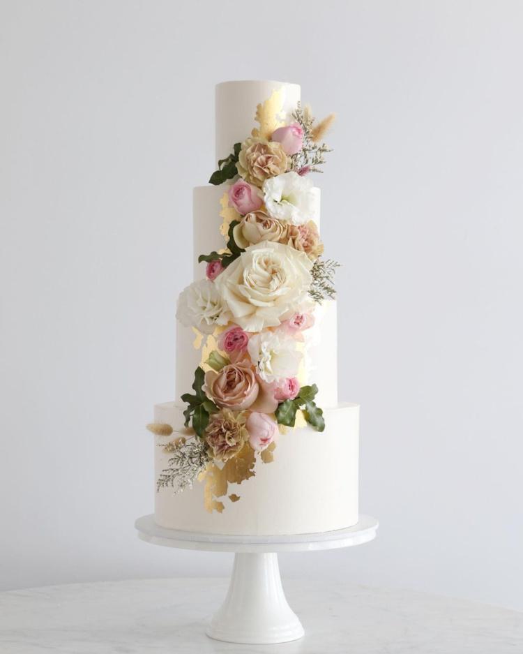 torta de matrimonio elegante de cuatro pisos con flores naturales