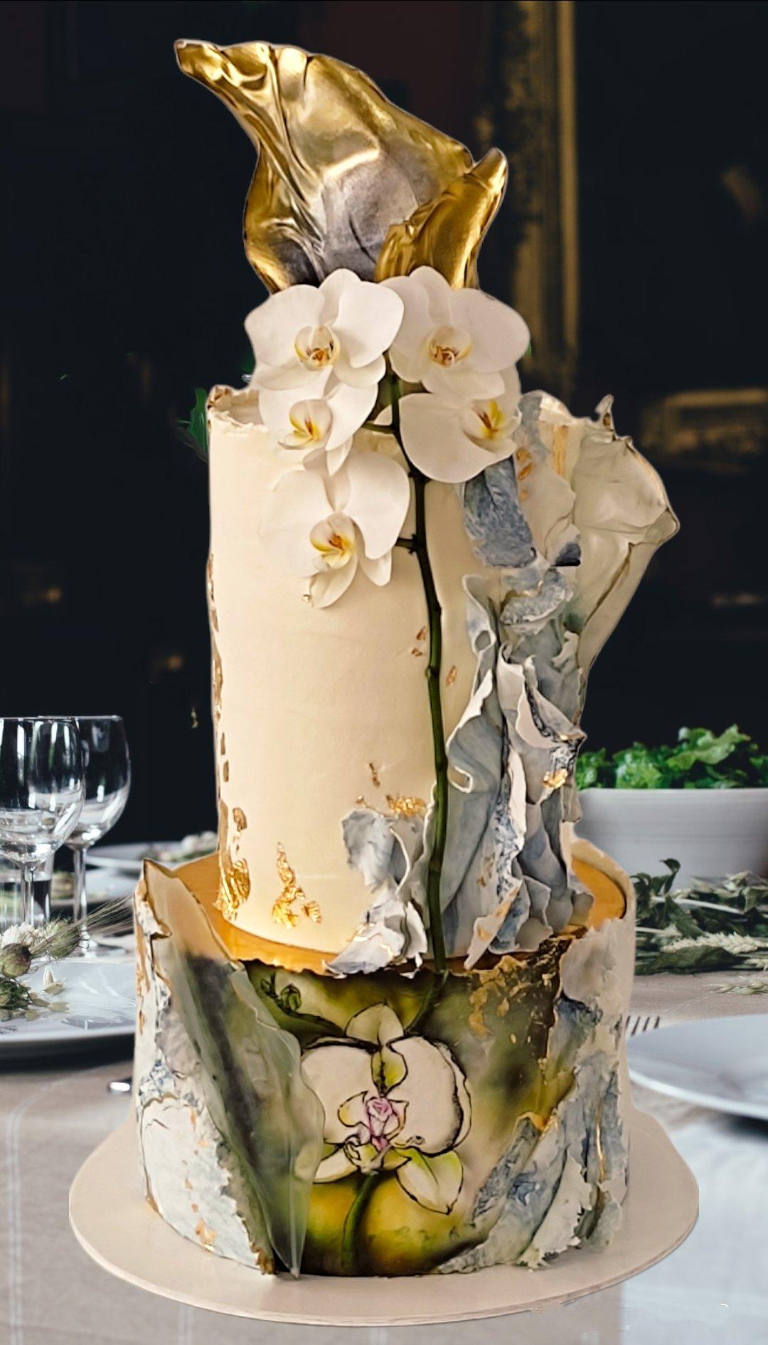 torta de matrimonio elegante de dos niveles con decoración floral y dorado