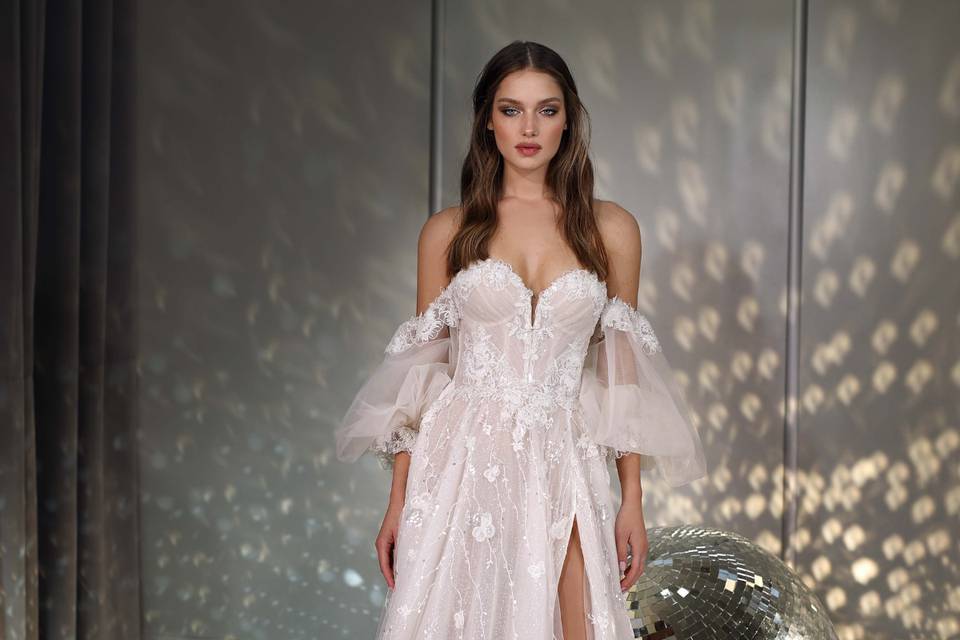 vestido de novia con brillos y encaje con escote hombros caídos y abertura en la pierna