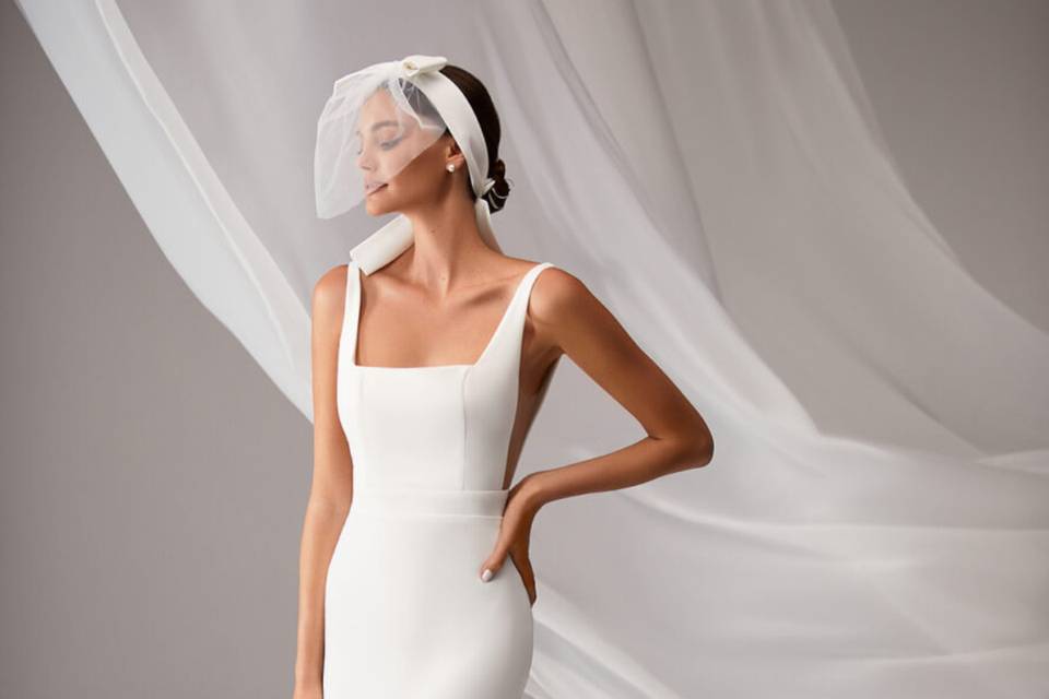 chica con vestido de novia blanco escote cuadrado con tocado de rejilla que cubre su rostro