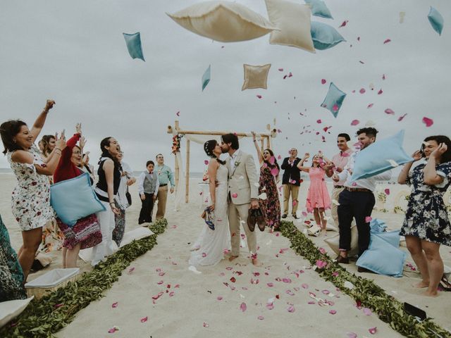Salida de novios de ceremonia en matrimonio en la playa los invitados lanzan cojines