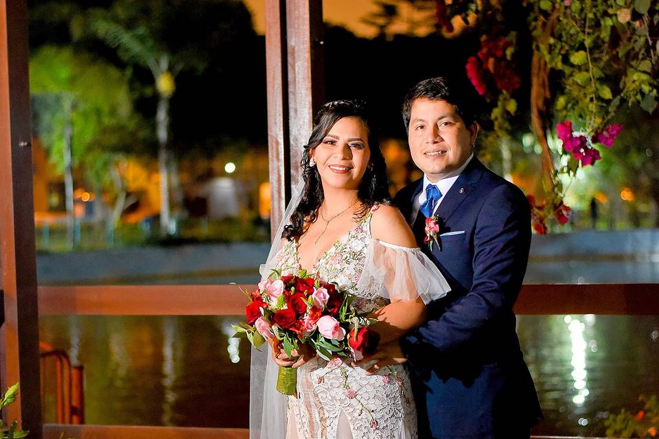 Recién casados posando frente a un lago