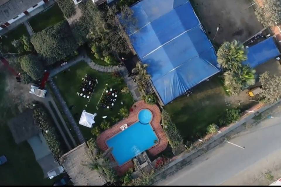 Vista aérea piscina y jardin