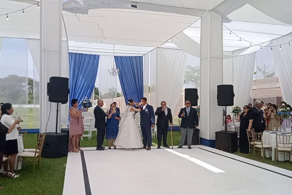 Invitados en un jardín con carpa blanca