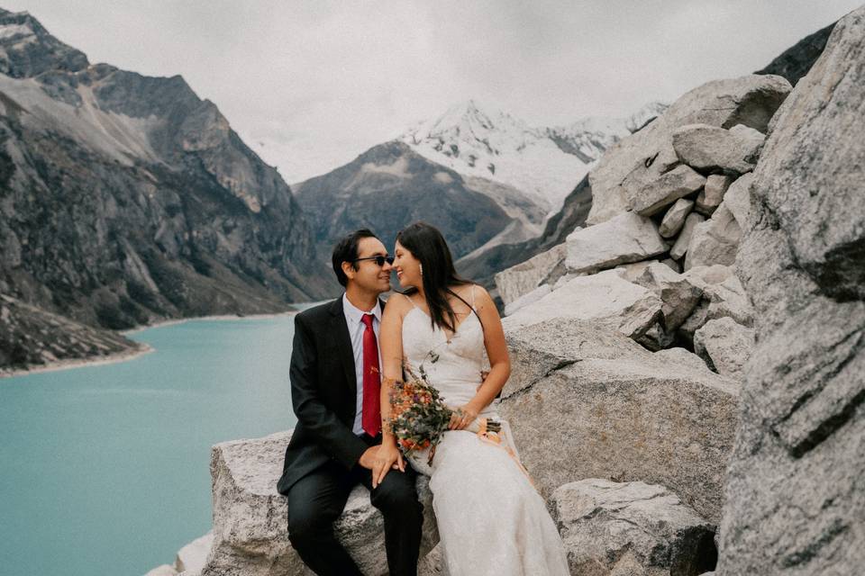 Pareja sentados en las rocas frente a un río