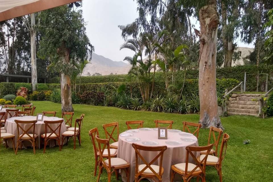 Sillas de madera y mesa redonda en jardín