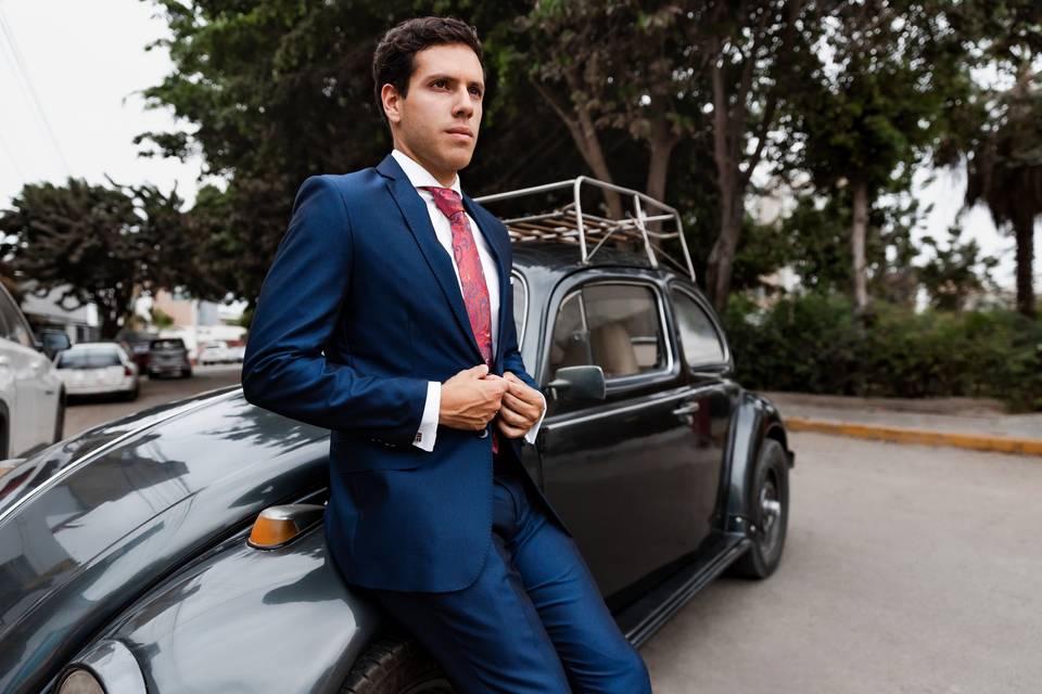 HOmbre con traje sobre un coche