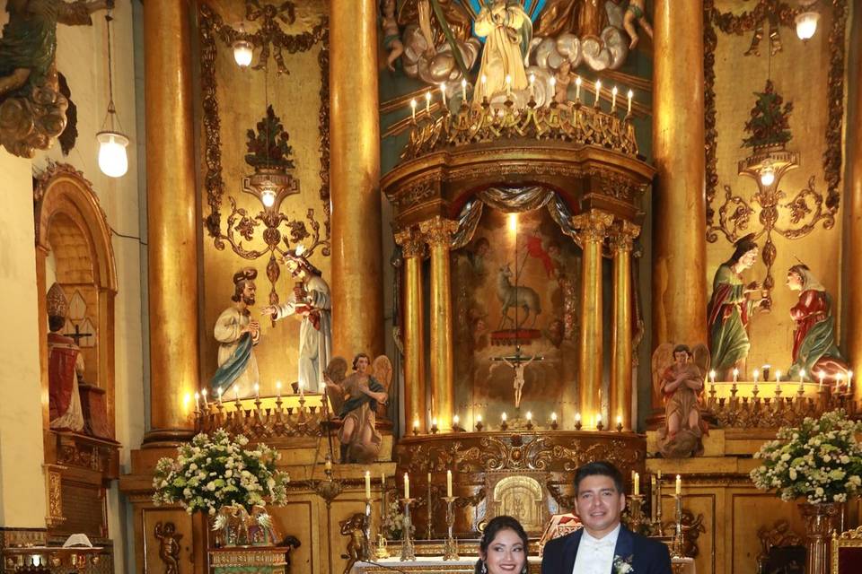 Novios posando en el pasillo de la iglesia