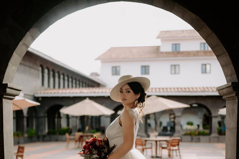 Novia posando bajo un arco