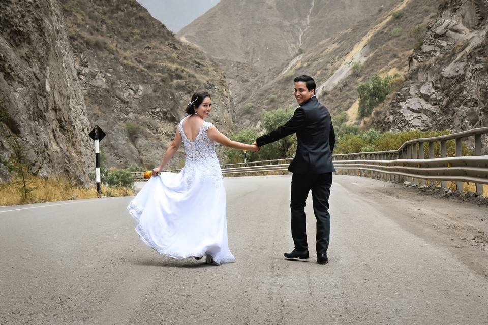 Pareja tomada de la mano en medio de la carretera